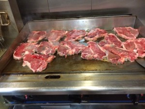 Large steaks cooking on the grill in kitchen