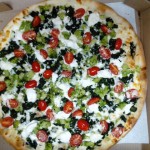 Broccoli and tomato pizza in pizza box