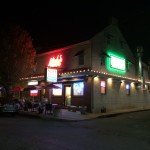 Exterior of Nick's Pizza Restaurant at night with neon lights